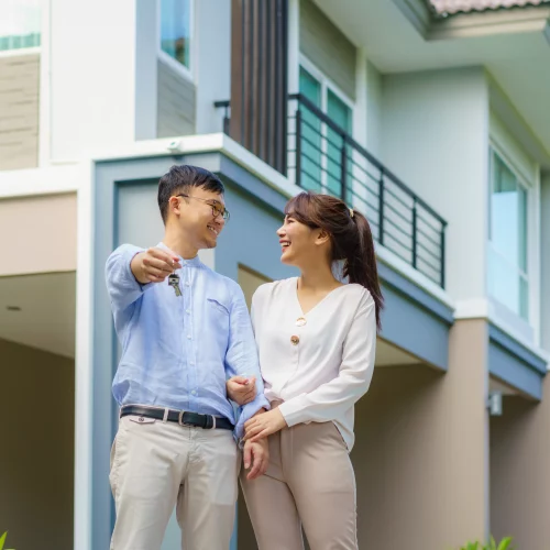 portrait-asian-young-couple-standing-hugging-together-holding-house-key-looking-happy-front-their-new-house-start-new-life-family-age-home-real-estate-people-concept